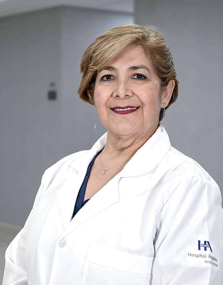 Es la foto de perfil de una otorrinolaringóloga en Ciudad de México de Hospital Angeles Lindavista. Tiene el cabello color café. Usa lentes, aretes largos, una bata blanca y un uniforme médico rosa.