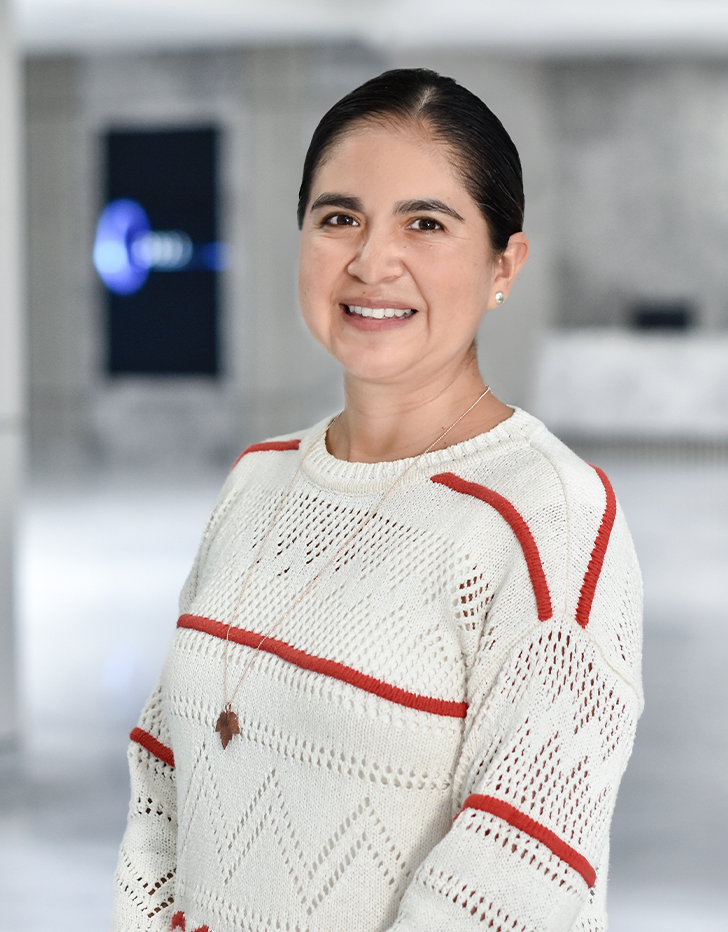 Es la foto de perfil de una especialista en inmunología y alergia en Querétaro de Hospital Angeles Centro Sur. La doctora tiene un suéter blanco con rayas rojas cabello recogido.