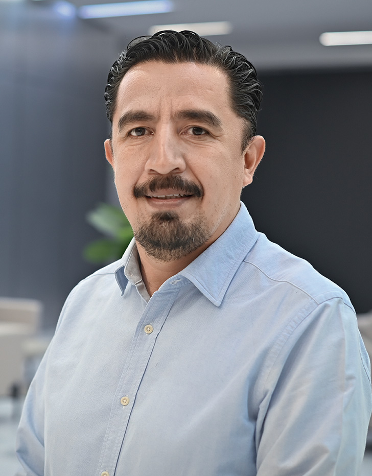 Es la foto de perfil de un oncólogo médico pediátrico en Querétaro de Hospital Angeles Centro Sur. El doctor tiene una camisa azul cielo barba bigote y cabello oscuro.