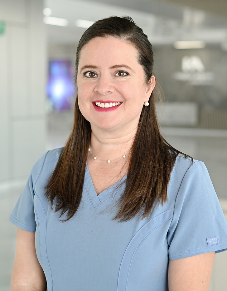 Es la foto de perfil de una otorrinolaringóloga en Querétaro de Hospital Angeles Centro Sur. La doctora viste una un uniforme azul cielo un cabello recogido y tiene joyería con perlas.