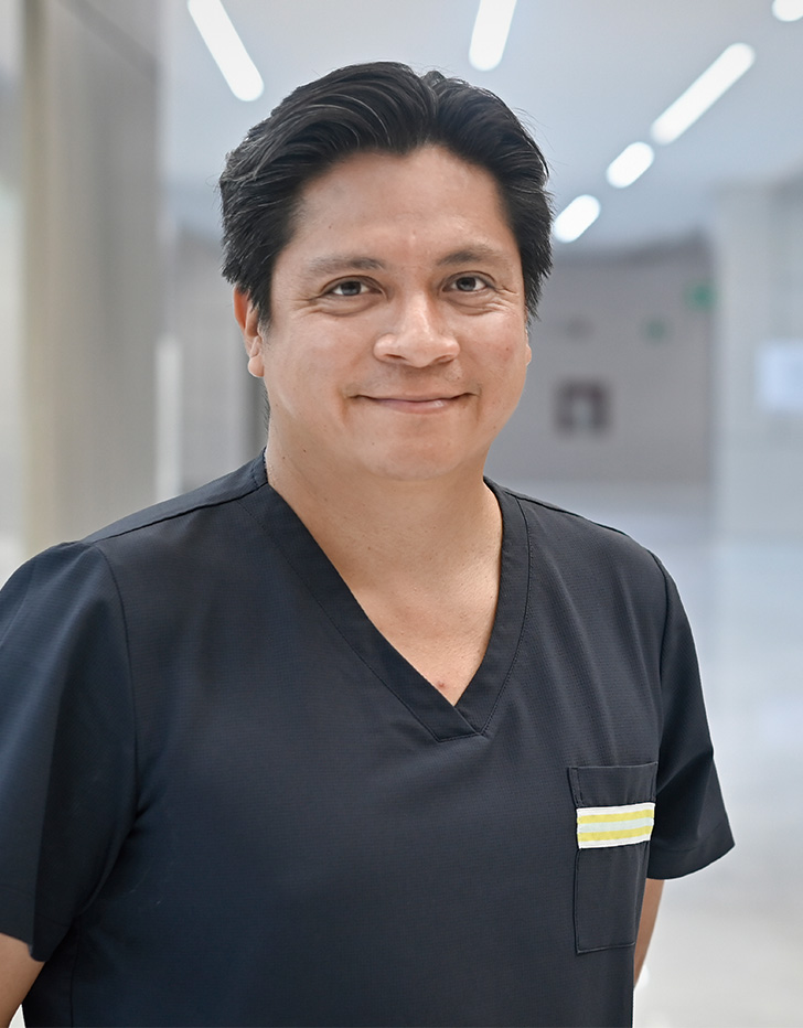 Es la foto de perfil de un anestesiólogo en Querétaro de Hospital Angeles Centro Sur. El doctor tiene un uniforme negro y está sonriendo.