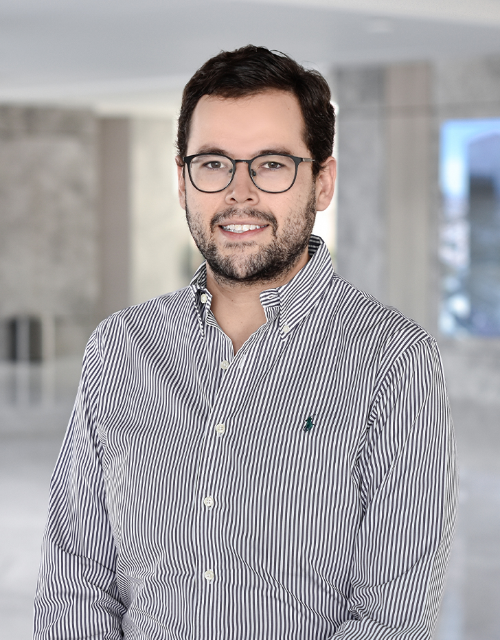 Es la foto de perfil de un pediatra en Querétaro de Hospital Angeles Centro Sur. El doctor tiene la camisa de rayas blancas con gris y usa lentes.