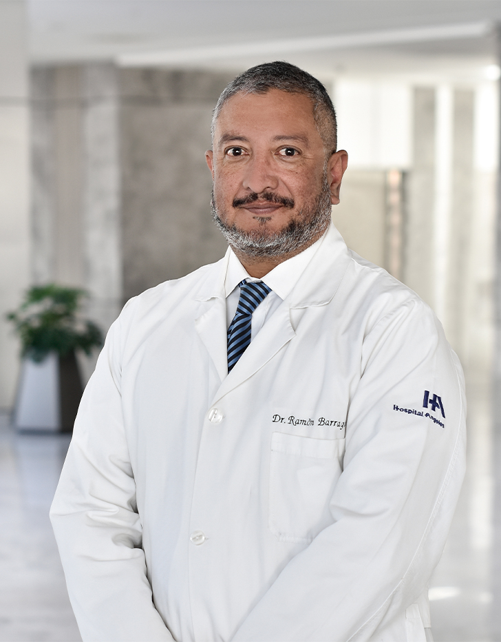 Es la foto de perfil de un cirujano general en Querétaro de Hospital Angeles Centro Sur. El doctor viste una bata blanca y camisa blanca, con una corbata azul con rayas blancas.