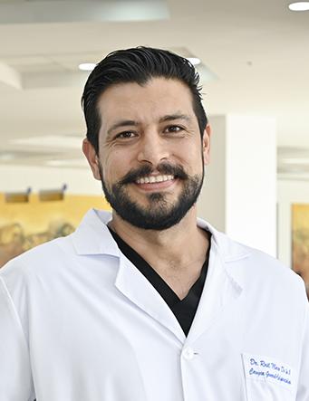 Es la foto de perfil de un coloproctólogo en Ciudad Juárez de Hospital Angeles Ciudad Juárez. Utiliza una bata blanca, tiene el cabello oscuro y barba.