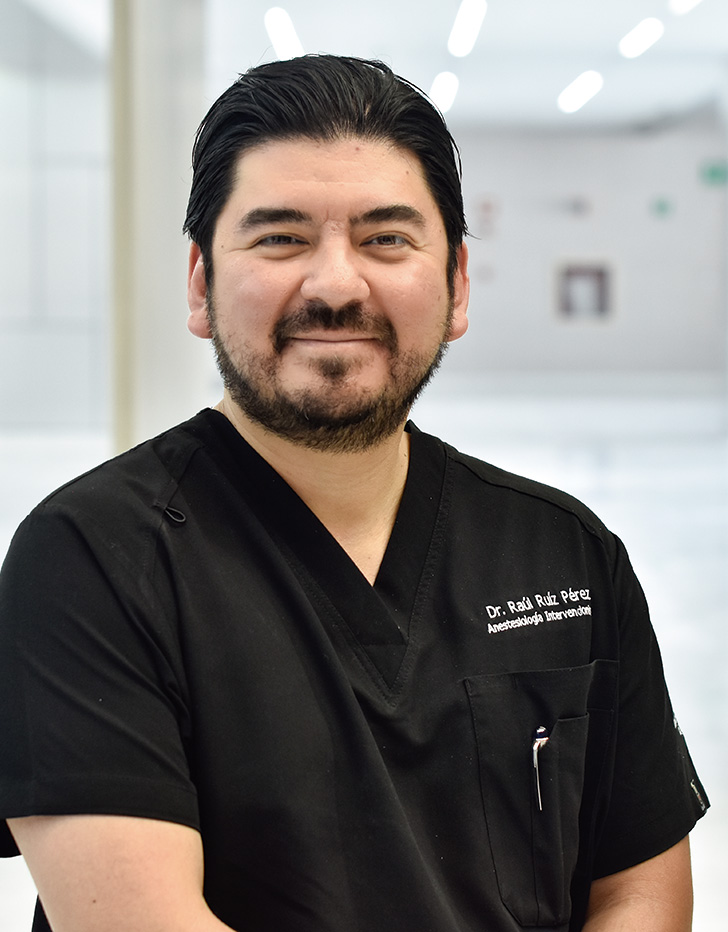 Es la foto de perfil de un anestesiólogo en Querétaro de Hospital Angeles Centro Sur. Usa un uniforme negro y está sonriendo, tiene barba y cabello oscuro.