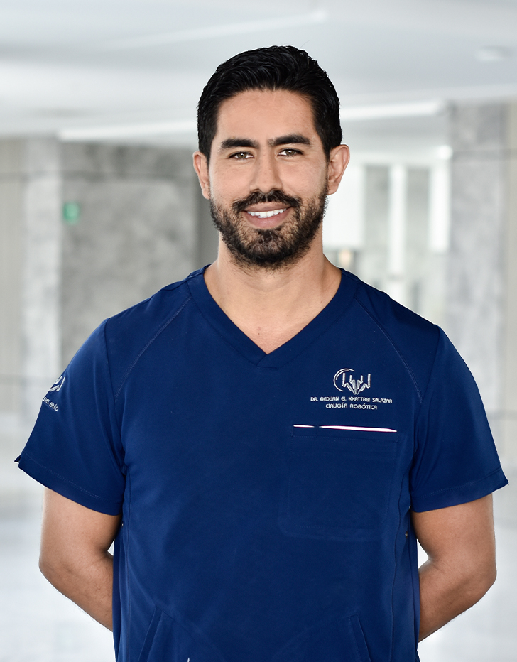 Es la foto de perfil de un urólogo en Querétaro de Hospital Angeles Centro Sur. Usa un uniforme azul marino , tiene barba y está sonriendo.