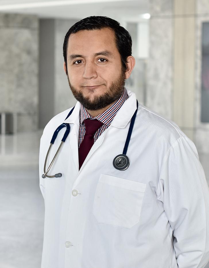 Es la foto de perfil de un nefrólogo pediátrico en Querétaro de Hospital Angeles Centro Sur. Usa una bata blanca, con una camisa con rayas y una corbata vino, tiene un estetoscopio en el cuello.