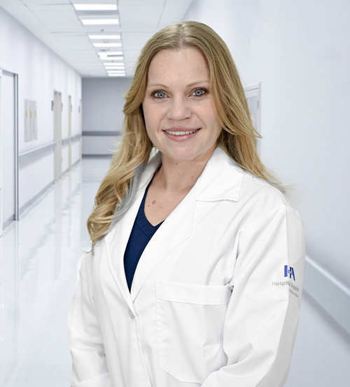 This is the profile photo of a specialist in endovascular therapy in neurology and a neurosurgeon México  Hospital Angeles Universidad México City. She is wearing a blue medical uniform. She has long, blonde hair. She is smiling.