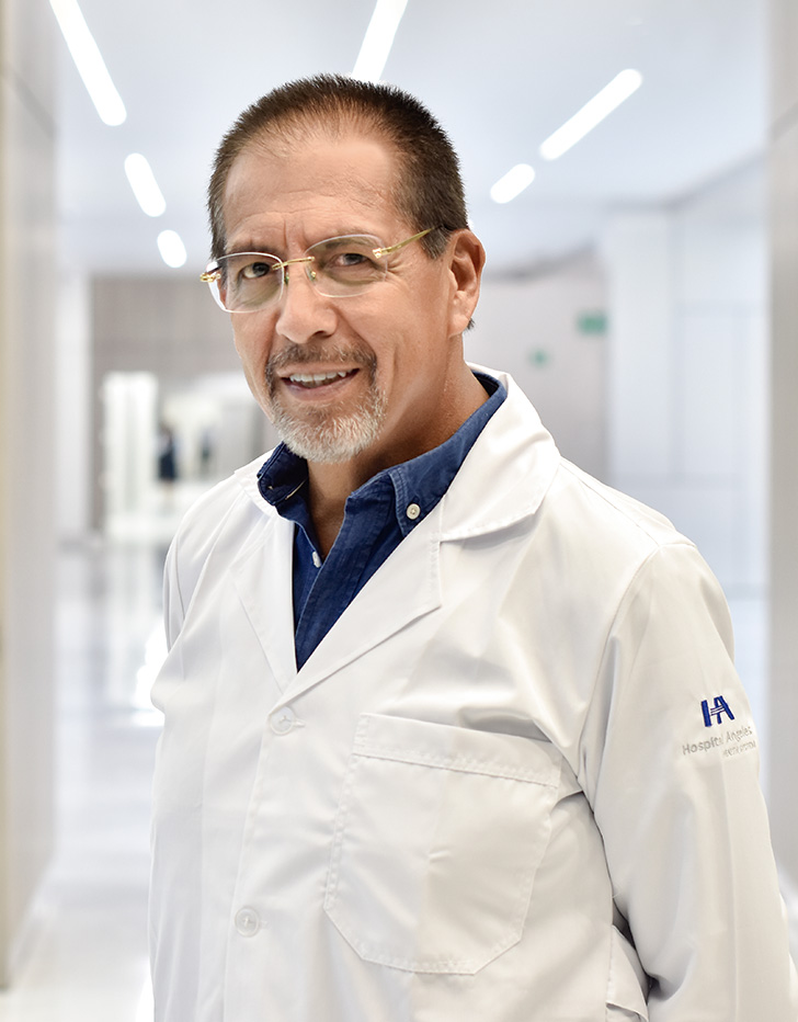 Es la foto de perfil de un cirujano general en Querétaro de Hospital Angeles Centro Sur. Usa una bata blanca, camisa azul y lentes.