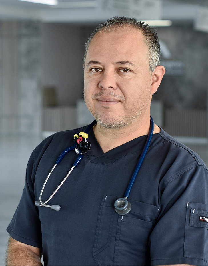 Es la foto de perfil de un pediatra en Querétaro de Hospital Angeles Centro Sur. Usa un uniforme azul marino, un estetoscopio y está sonriendo.